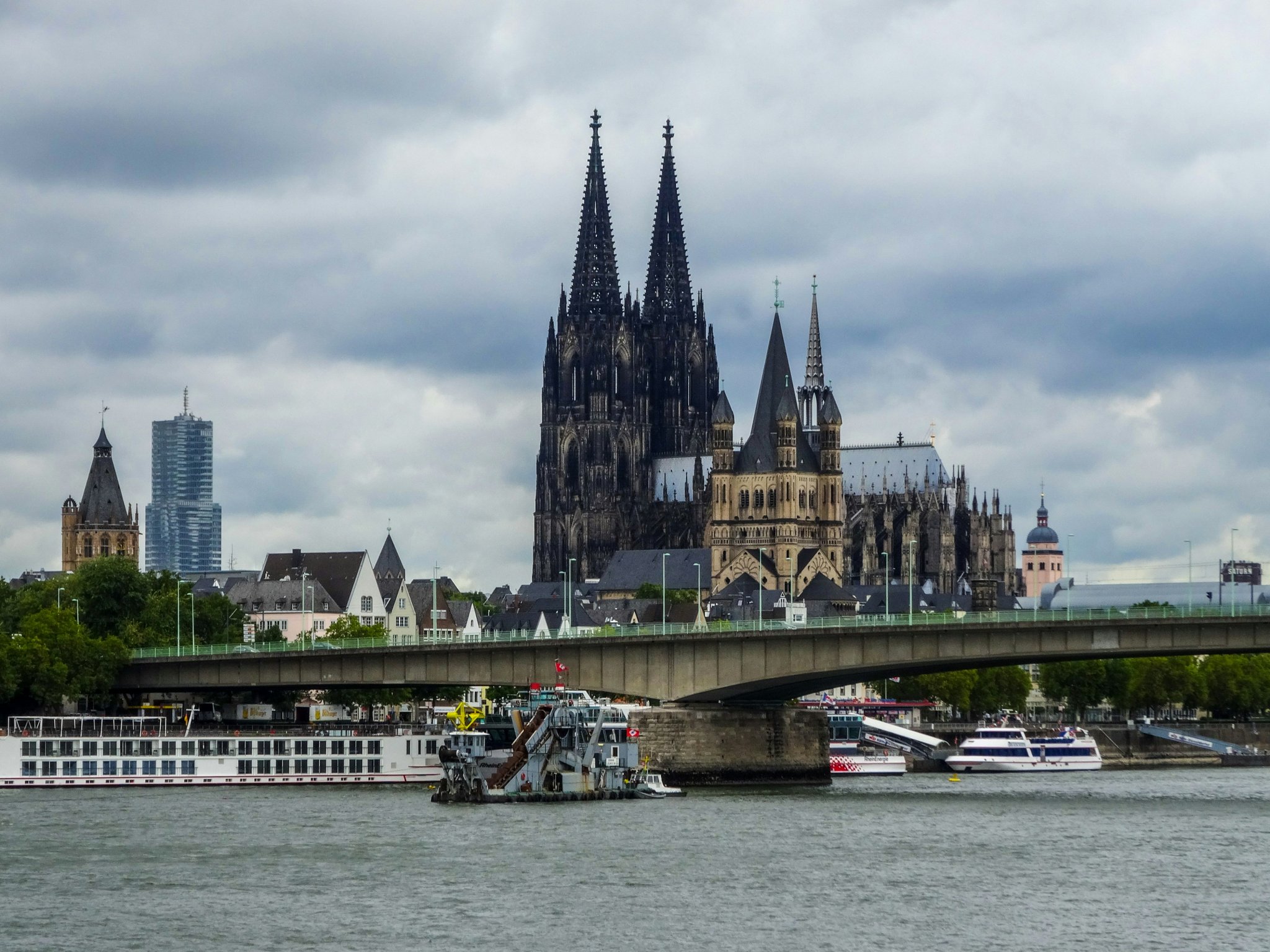 Blick über den Rhein auf den Kölner Dom, eine Rheinbrücke und Schiffe